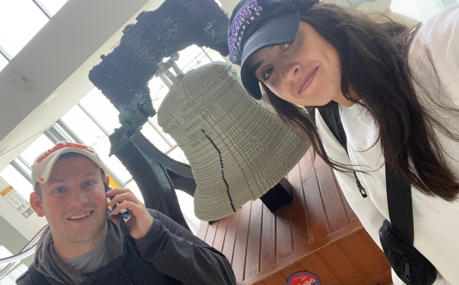 Rebecca and Tristan in front of Lego Liberty bell in PHL Airport